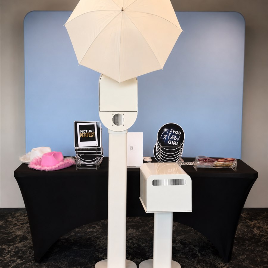 Photo booth props table with signage, sunglasses, and a cowboy hat