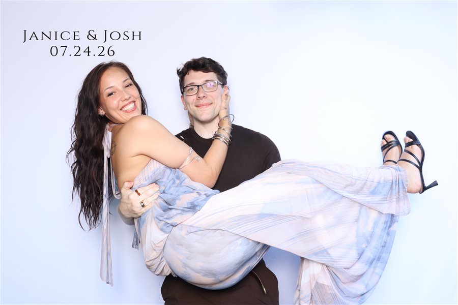 Janice and Josh sharing a playful moment at their wedding photo booth