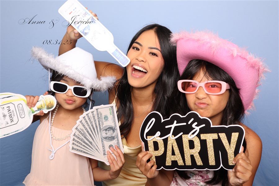 Family posing with party props at Anna and Jericho's wedding photo booth