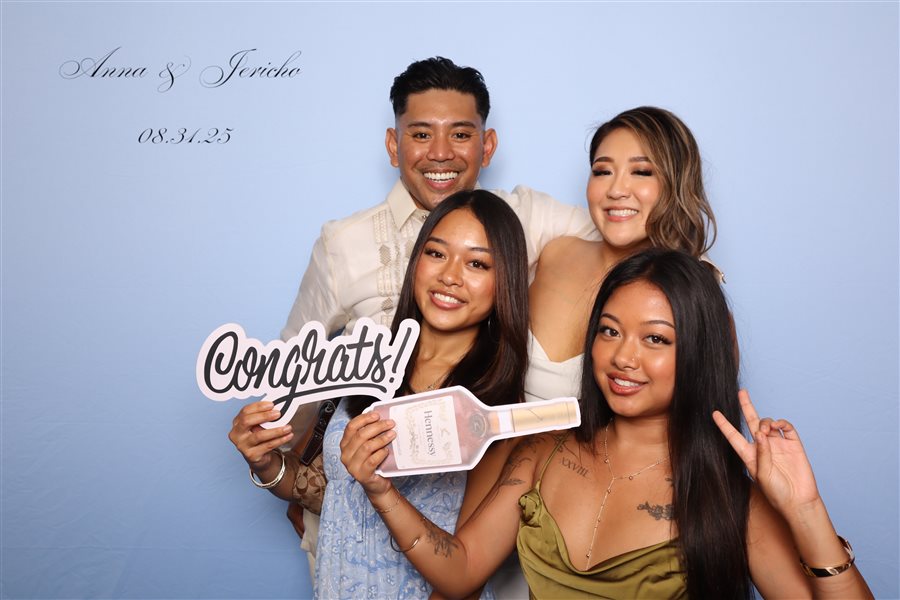 Group celebrating with a Congrats sign at Anna and Jericho's wedding photo booth