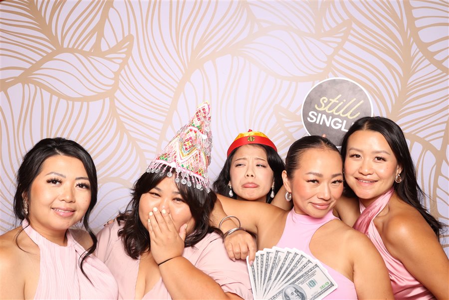 Bridesmaids posing with a Still Single sign at Richmond and Rose's wedding photo booth