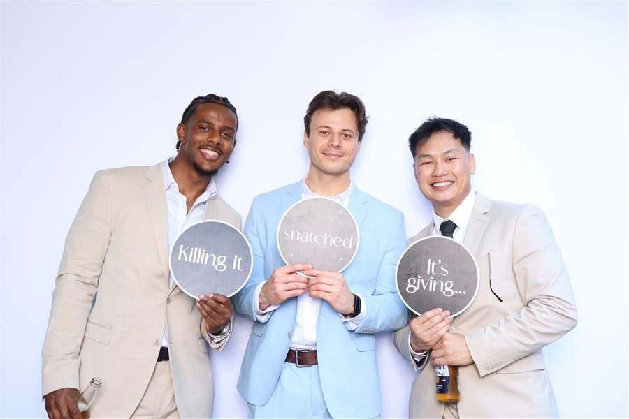 Groomsmen posing with fun signs at Janice and Josh's wedding photo booth