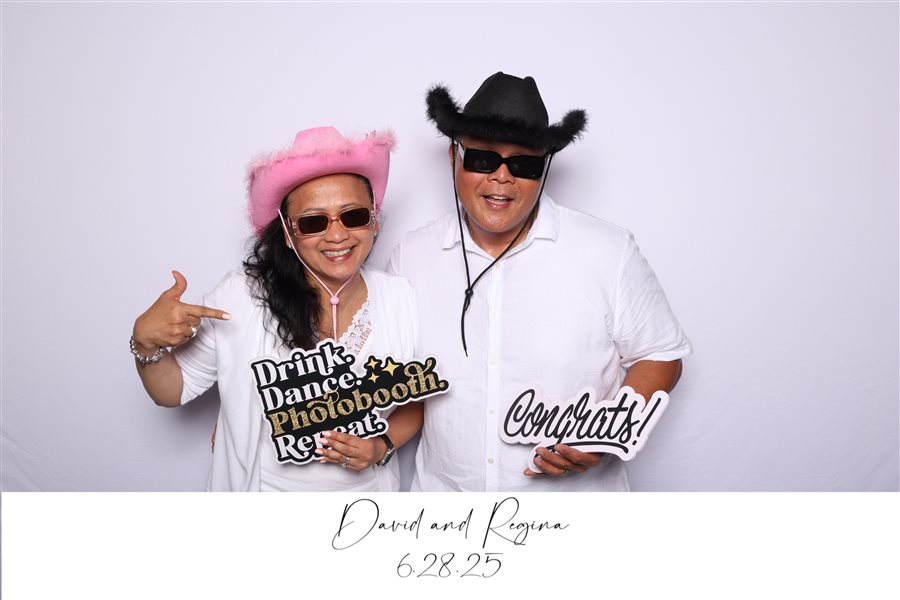 Guests wearing cowboy hats and posing with party signs at David and Regina's wedding photo booth