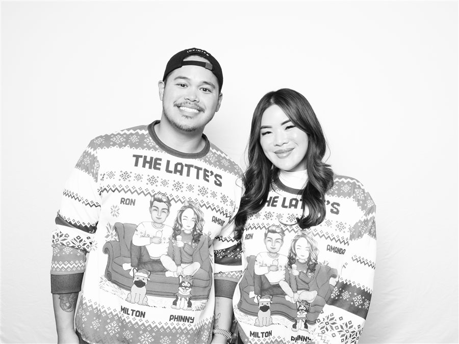 Coworkers posing in matching sweaters at the Infinite X Dynasty holiday party photo booth