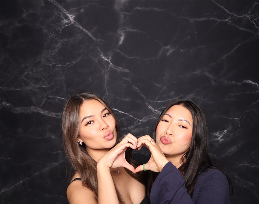 Friends making a heart with their hands at Tony's birthday photo booth