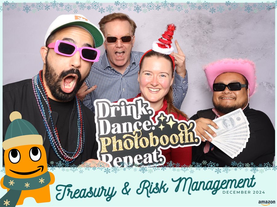 Guests posing with photo booth props at the Amazon Treasury & Risk Management holiday party