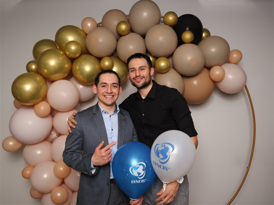 Coworkers posing at the SYNCIS Bellevue office grand opening photo booth